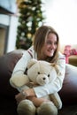 Smiling girl hugs teddy bear at christmas eve Royalty Free Stock Photo