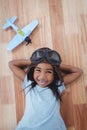 Smiling girl laying on the floor wearing aviator glasses and hat Royalty Free Stock Photo