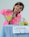 Smiling girl at lemonade stand pouring lemonade Royalty Free Stock Photo