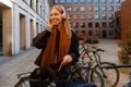 Smiling girl listening music with headphones while standing with bike outdoors Royalty Free Stock Photo