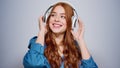 Smiling girl listening music indoors. Relaxed woman making movements in studio Royalty Free Stock Photo