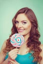 Smiling girl with lollipop candy on teal Royalty Free Stock Photo