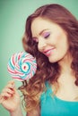 Smiling girl with lollipop candy on teal Royalty Free Stock Photo