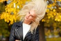 Smiling girl with long blonde flying hair in autumn park Royalty Free Stock Photo