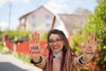 Smiling girl with long dreadlocks and eyeglasses in nude color trench is showing hands with written slogan `Our future Royalty Free Stock Photo