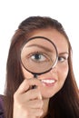 Smiling girl looking through magnifying glass