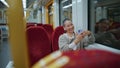 Smiling girl looking mobile phone in train. Happy bald woman reading message Royalty Free Stock Photo