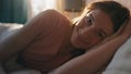 Smiling girl lying bed in sunlight closeup. Happy calm woman holding present box Royalty Free Stock Photo