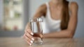 Smiling girl offers glass of water, keeps body hydrated, moisturized skin