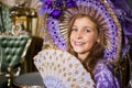 The smiling girl in old-fashione dress with fan in