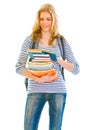 Smiling girl with pile of schoolbooks reading Royalty Free Stock Photo