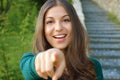 Smiling girl pointing finger at camera and toothy smile, focus on her face Royalty Free Stock Photo