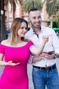 Smiling girl is pointing the way for young stranger