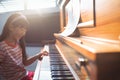 Smiling girl practicing piano in class