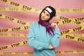 Smiling girl with purple hair tips dressed in blue sweatshirt and black hat stands on the background of pink wall with Royalty Free Stock Photo