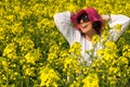 Smiling girl in the rapeseed yellow field