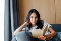 Smiling girl reading book on sofa at home Royalty Free Stock Photo