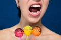 Smiling girl with red, yellow and orange cakepops Royalty Free Stock Photo
