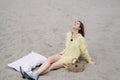 Smiling girl relaxing on the beach with champagne and pillow