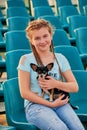 Smiling girl relaxing with dog. the girl child on the seats of the stadium. Royalty Free Stock Photo