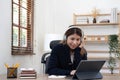 smiling girl relaxing at home She is listening to music using her laptop and wearing white headphones. Royalty Free Stock Photo