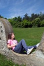 Smiling Girl Resting On The Stonewall And Daydreaming In The Park At Sunny Spring Day