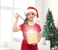 Smiling girl in santa helper hat with gift box Royalty Free Stock Photo