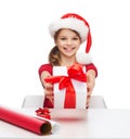 Smiling girl in santa helper hat with gift box Royalty Free Stock Photo