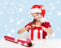 Smiling girl in santa helper hat with gift box Royalty Free Stock Photo