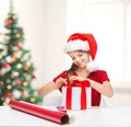 Smiling girl in santa helper hat with gift box Royalty Free Stock Photo