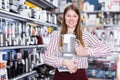 Smiling girl seller showing liquidiser in shop