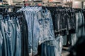 Smiling girl shopper choosing new jeans at store