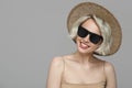 Smiling girl with a short haircut in a hat and sunglasses.