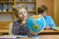 Smiling girl showing on globe at school classroom. Educational and school concept Royalty Free Stock Photo
