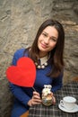 Smiling girl with a sign in the form of heart