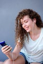 Smiling girl sitting with cellphone listening to music Royalty Free Stock Photo