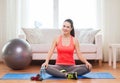 Smiling girl sitting on mat with sports equipment Royalty Free Stock Photo