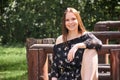 Smiling girl sitting on a park bench in a free pose Royalty Free Stock Photo