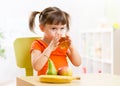 Smiling girl sitting on the table with fruits and Royalty Free Stock Photo