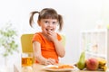 Smiling girl sitting on the table with fruits and Royalty Free Stock Photo