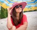 Smiling girl sitting under umbrella on the sand Royalty Free Stock Photo