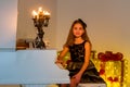 Portrait of Beautiful Smiling Girl Sitting at Piano Looking at Camera. Royalty Free Stock Photo