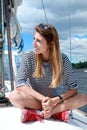Smiling girl sitting on yacht deck. Royalty Free Stock Photo