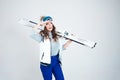 Smiling girl skier in a hat and mask for skiing. A young woman in clothes for skiing and outdoor activities. Royalty Free Stock Photo