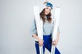 Smiling girl skier in a hat and mask for skiing. A young woman in clothes for skiing and outdoor activities. Royalty Free Stock Photo