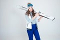 Smiling girl skier in a hat and mask for skiing. A young woman in clothes for skiing and outdoor activities. Royalty Free Stock Photo