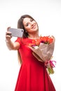 Smiling girl standing with a bouquet of colored tulips in their hands, make selfie phone on white Royalty Free Stock Photo