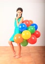 Smiling girl standing posing with inflating balloons