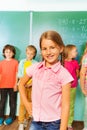 Smiling girl stands near green blackboard Royalty Free Stock Photo