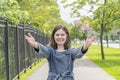 A smiling girl stands on the street against the background of the road and the park Royalty Free Stock Photo